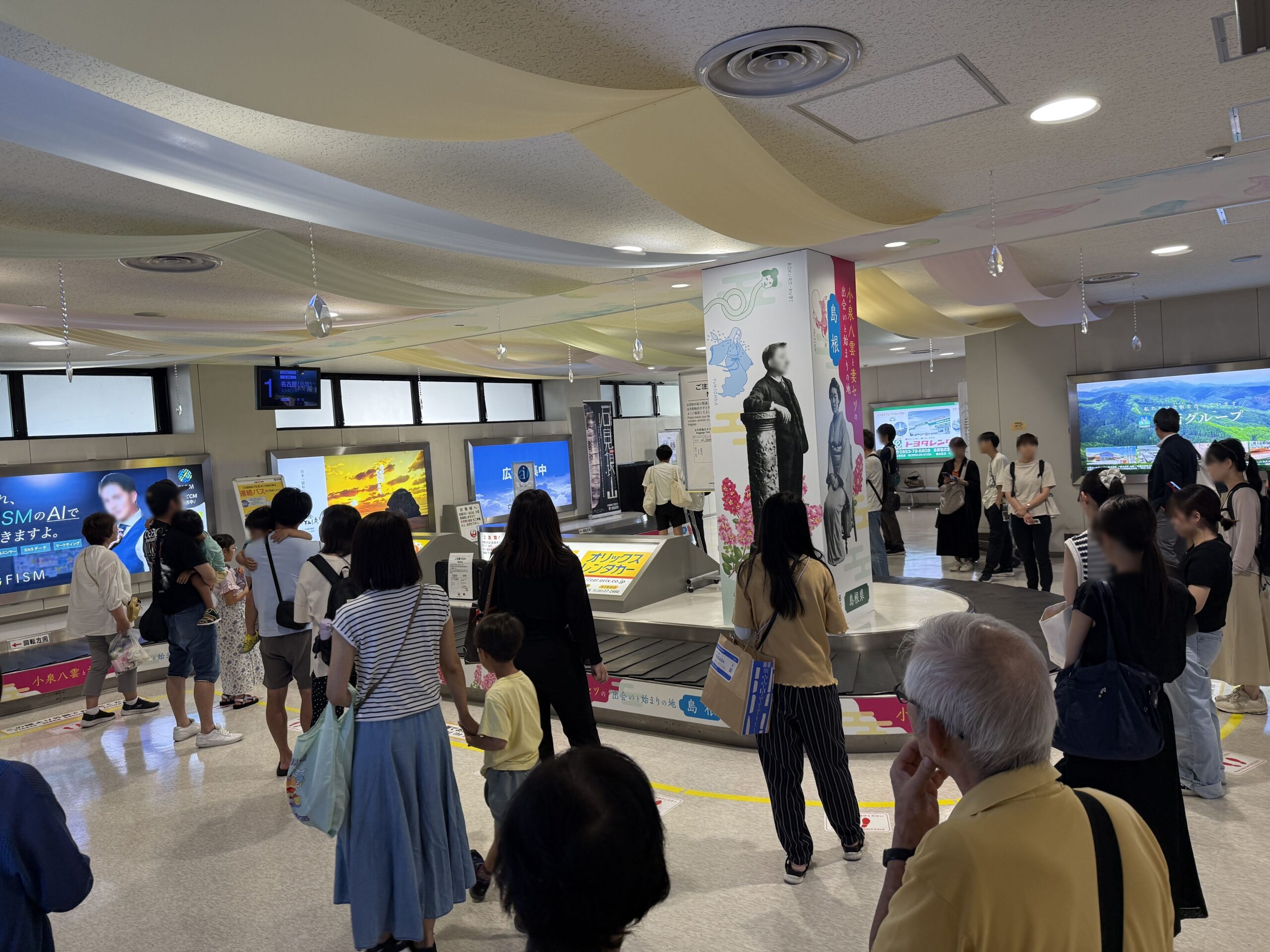 出雲空港の到着ロビー、手荷物受取所と出迎えの人々